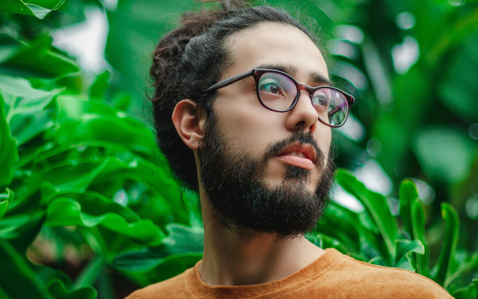 Homme barbu dans un décor naturel illustrant les bienfaits d’une huile à barbe bio